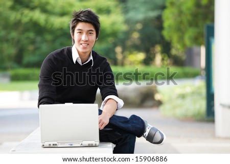 A shot of an asian student studying on his laptop