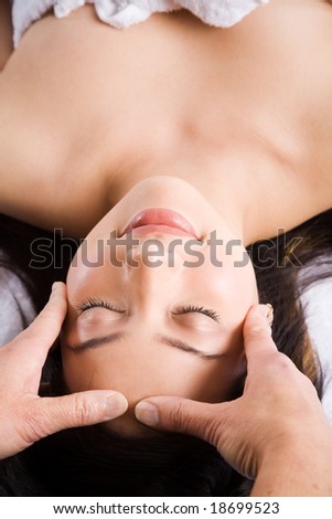 A beautiful asian woman getting a massage in a spa salon