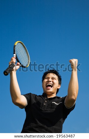 A happy asian tennis player in joy of winning