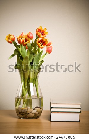 A shot of tulips in a vase and books, home decoration concept