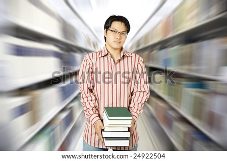 An asian college student carrying books at the library