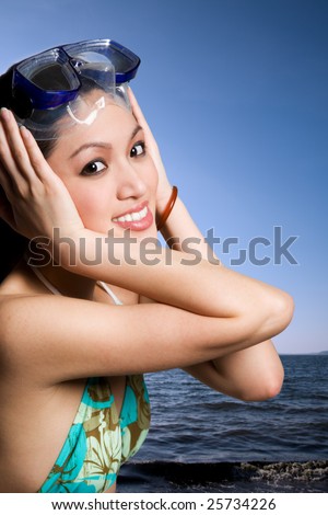 stock photo A beautiful asian woman in bikini at the beach wearing diving 