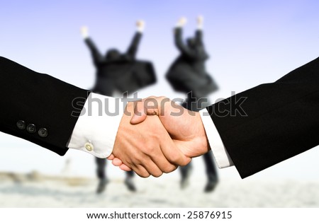 Two businessmen shaking hands with other two businessmen celebrating in the background, can be used for success concept