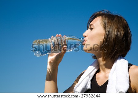 A beautiful caucasian girl drinking water during exercise