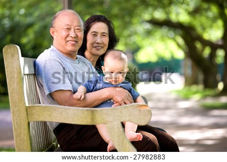 A shot of a cute asian child with his grandparents in a park