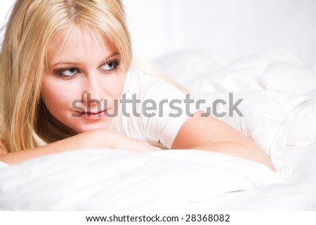 A beautiful caucasian blonde woman lying down on the bed