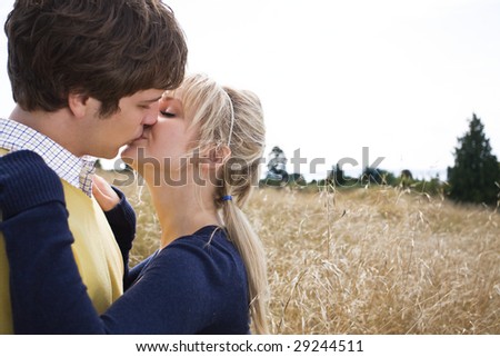 A young caucasian couple in love kissing outdoor