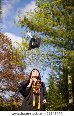 A happy beautiful graduation girl throwing her cap in the air