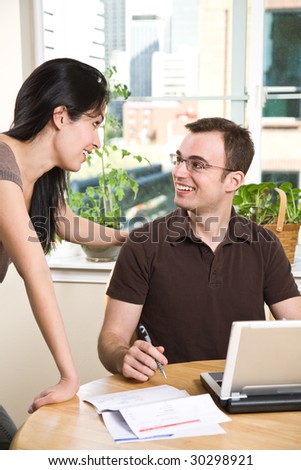 A happy couple paying bills by using online banking at home