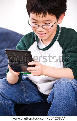 A shot of an asian boy playing electronic games
