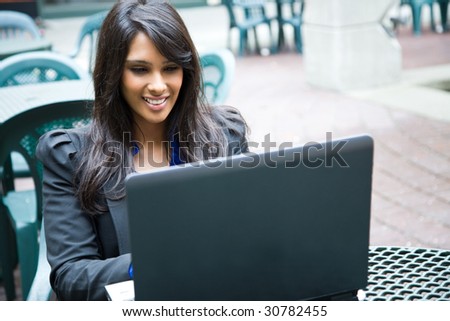 A shot of an indian businesswoman working on her laptop outdoor