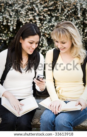 A shot of two college students texting text messages on campus