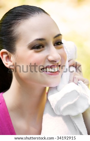 A beautiful caucasian woman doing exercise wipes away her sweat