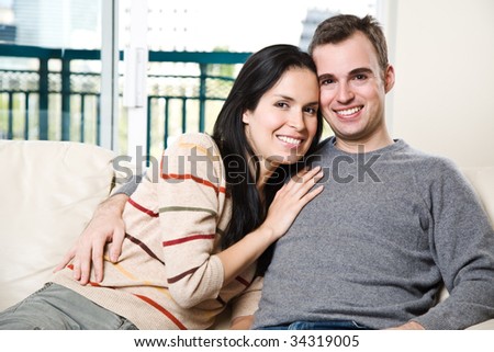 A happy couple sitting on the couch and relaxing at home