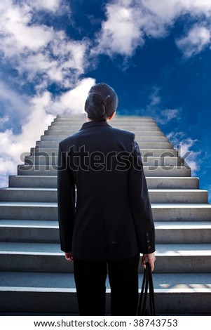 A conceptual shot of a businesswoman at the bottom of the stairs