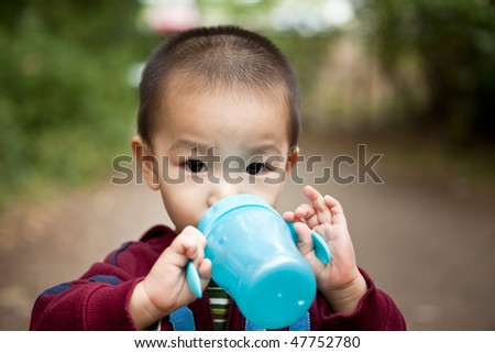A portrait of an asian boy drinking from his cup