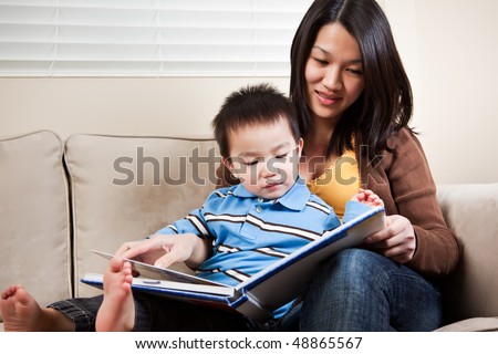 A portrait of a mother and a son reading a book