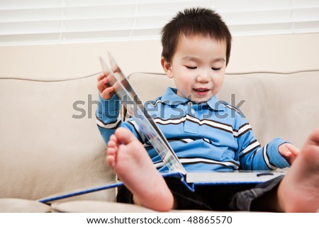 A portrait of an asian boy reading a book