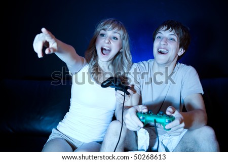 A shot of a young couple playing video games in the living room