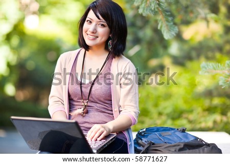 Mixed race college student working on laptop at campus