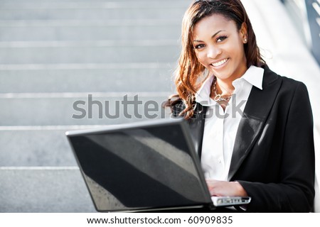 A shot of a beautiful black businesswoman working on her laptop outdoor