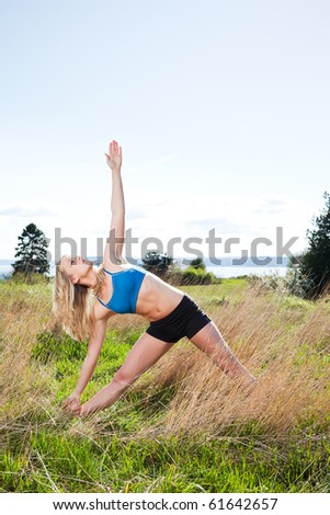 A beautiful caucasian woman practicing yoga outdoor in a park