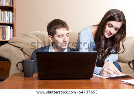 A couple paying bills by using online banking at home