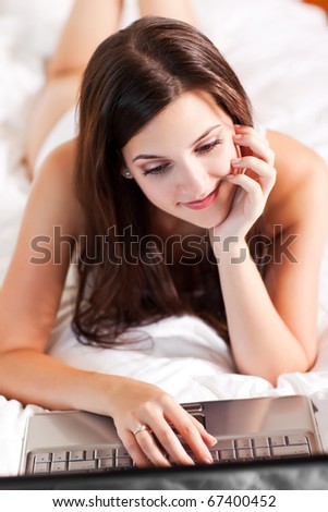 A shot of a beautiful woman using a laptop on the bed