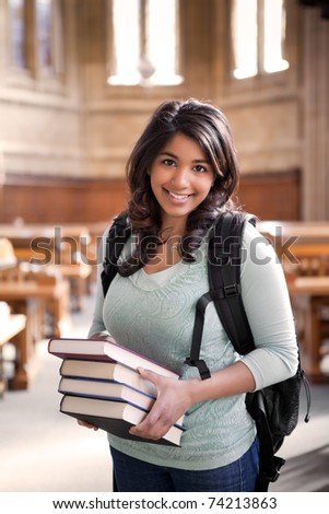 A shot of an asian student carrying books in a library