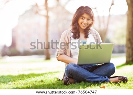 A shot of an asian student using laptop on campus