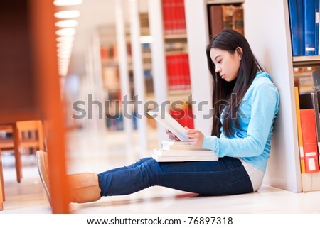 A portrait of an Asian college student studying in the library