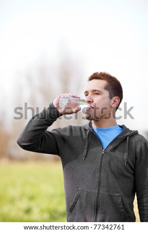 A shot of a mixed race man drinking water outdoor