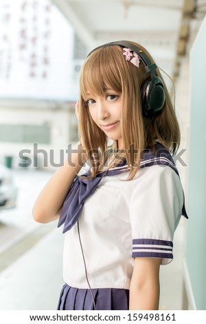 Asin girl in student sailor suit  japanese style listen to music by headset joshi koukousei