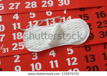 The sanitary napkin lying on a red calendar.
