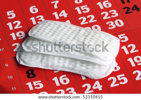 The sanitary napkin lying on a red calendar.