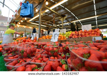 BIRMINGHAM, ENGLAND - JUNE 13: Unknown man trades a fruits in Bull Ring market on June 13, 2013 in Birmingham, England. Birmingham's outdoor Bull Ring market sees over six million shoppers every year