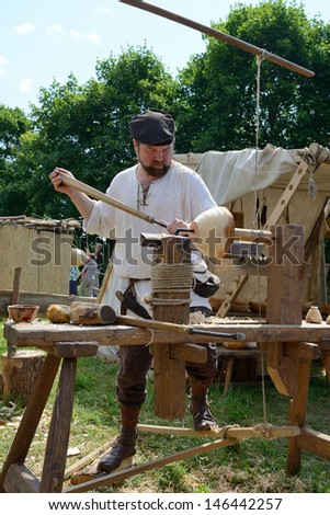 KERNAVE, LITHUANIA - JULY 7: Unidentified people carve wood in the 14th International Festival of Experimental Archaeology on July 7, 2013. Its a most popular folklore event on July in Lithuania