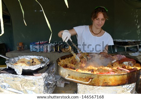 KERNAVE, LITHUANIA - JULY 7: Unidentified people make food at 14th International Festival of Experimental Archaeology on July 7, 2013. Its a most popular folklore event on July in Lithuania