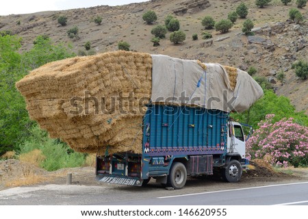 ATLAS, MOROCCO - JULY 10: Overloaded truck staying on road, July 10, 2013 in Atlas Mountains, Morocco. Road in Atlas Mountains very popular tourist route in central Morocco.