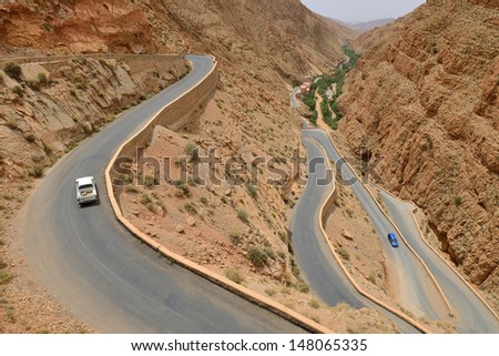 DADES GORGES, MOROCCO - JULY 11: Cars on a winding road, July 11, 2013 in Dades Gorges, Morocco. Road in Dades Gorges very popular tourist route in east Morocco.