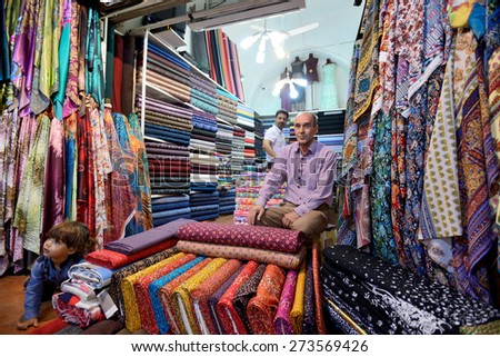 SHIRAZ - APRIL 15: Unknown man trades traditional iranian fabrics in market (Vakil Bazaar) in Shiraz, Iran on April 15, 2015. Vakil Bazaar is the most important tourist attraction in Shiraz, Iran.