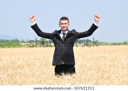 Business man standing in wheat