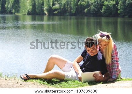 Young couple at notebook in nature
