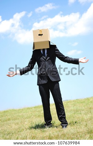 Business man with box on head in nature