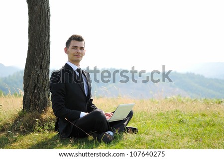 Business man with laptop in nature