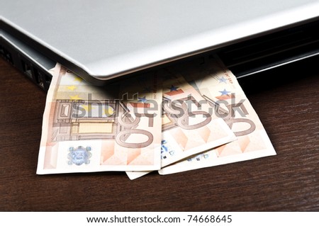 Closeup to laptop and euro banknotes