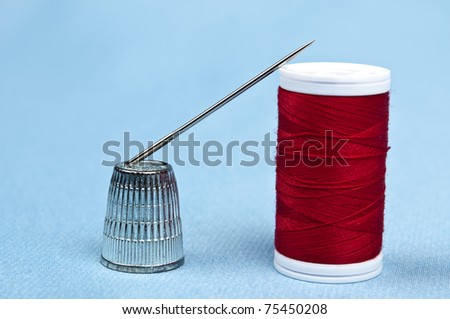 Thimble and thread on blue material