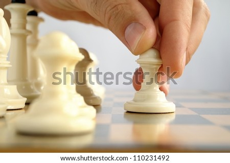 man playing chess, and shows the hand of chess pieces