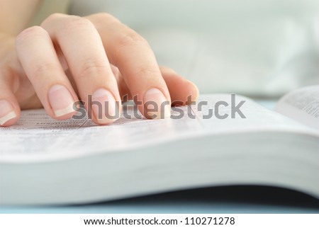 girl reading a book, shows a close-up hand and a book