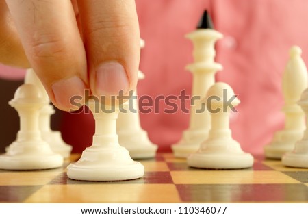 man playing chess, and shows the hand of chess pieces